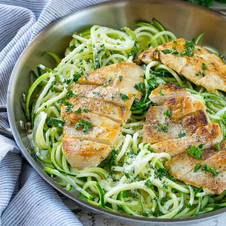 healthy chicken alfredo zoodles in pan with chicken breasts