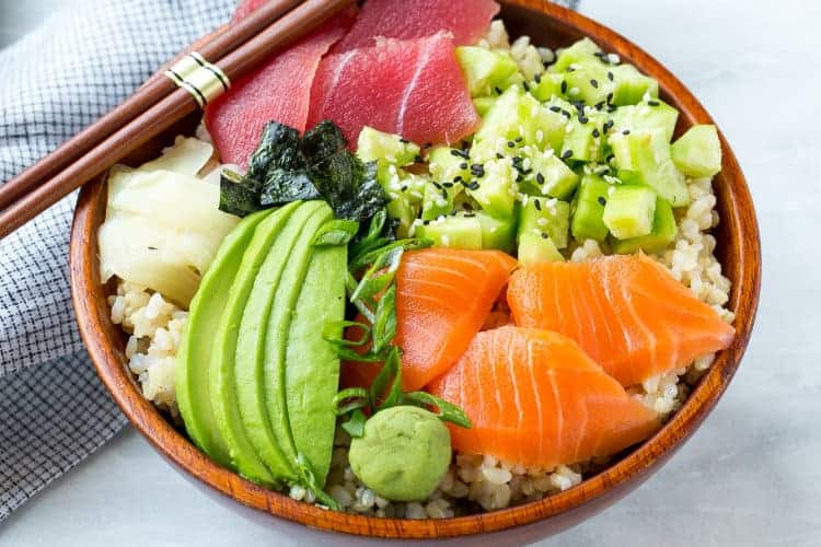 deconstructed sushi recipe in bowl with veggies and chopsticks 
