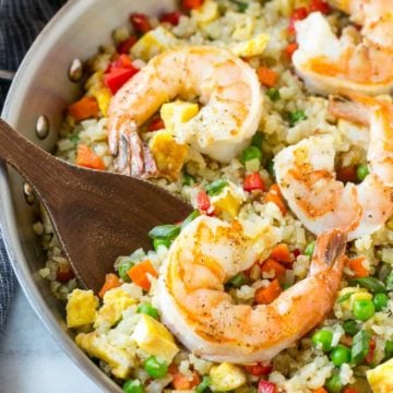 Shrimp Cauliflower Fried Rice in skillet with wooden spoon