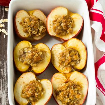 baked apples stuffed with cinnamon oats in a white dish