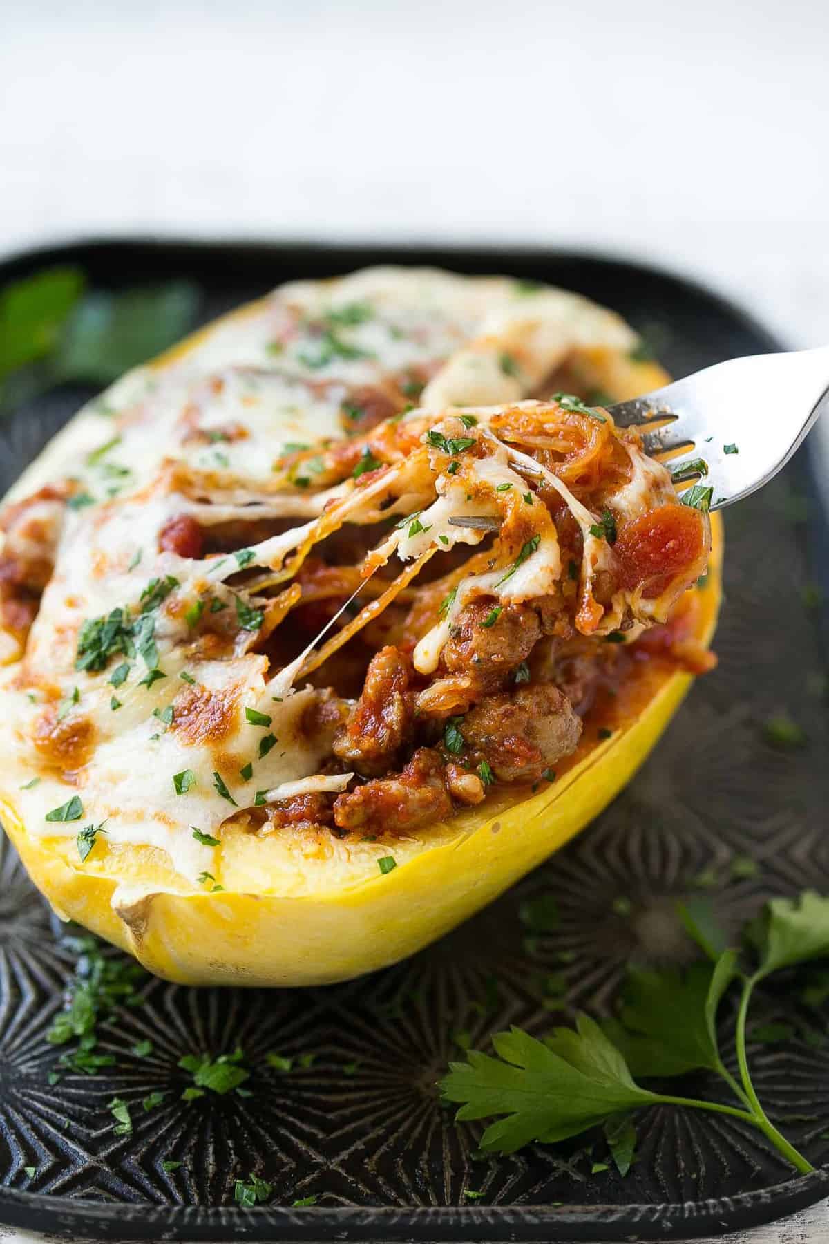 baked squash with fork grabbing bite, melted cheese