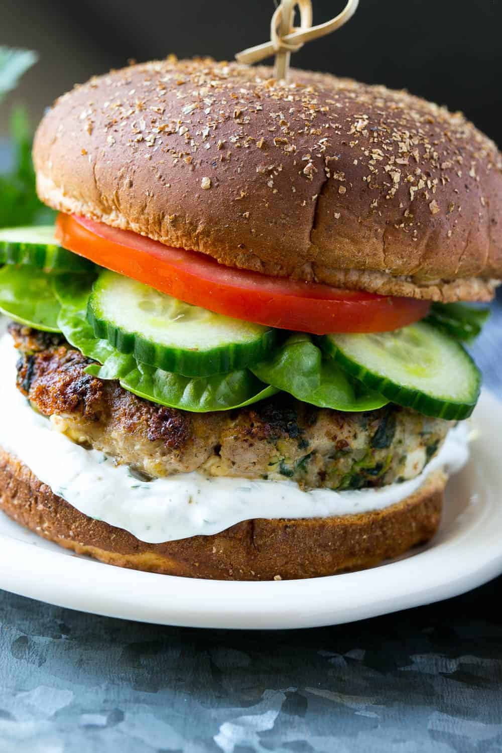 turkey burger with spinach and feta on plate with tzatziki sauce 