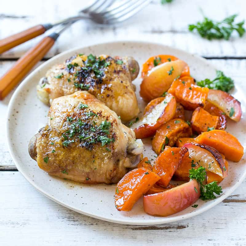 roasted chicken thighs recipe with sweet potatoes and apples on a white plate 