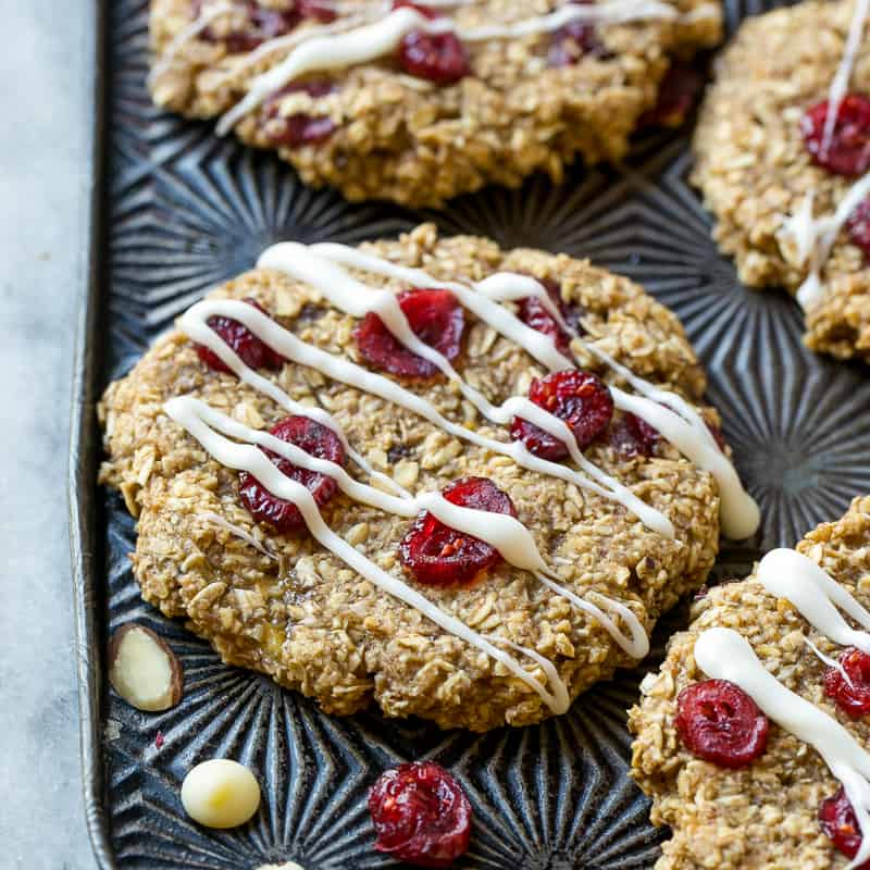 close up Almond Breakfast Cookies on a pan with white chocolate drizzle 