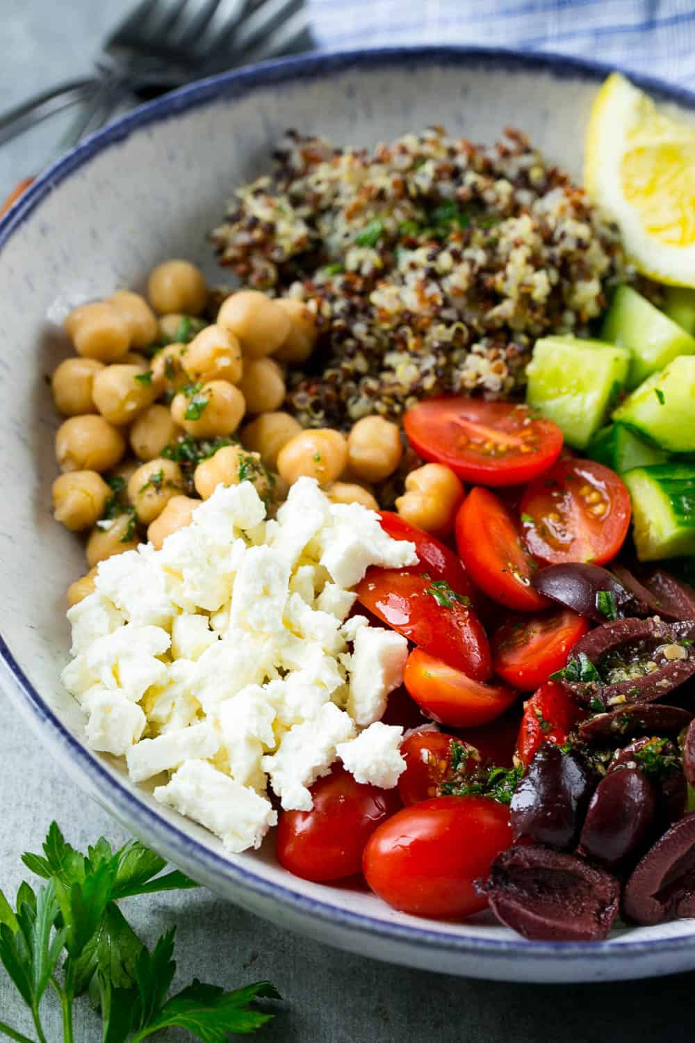 quinoa salad with feta in bowl with chickpeas, cucumbers, olives, and tomatoes 