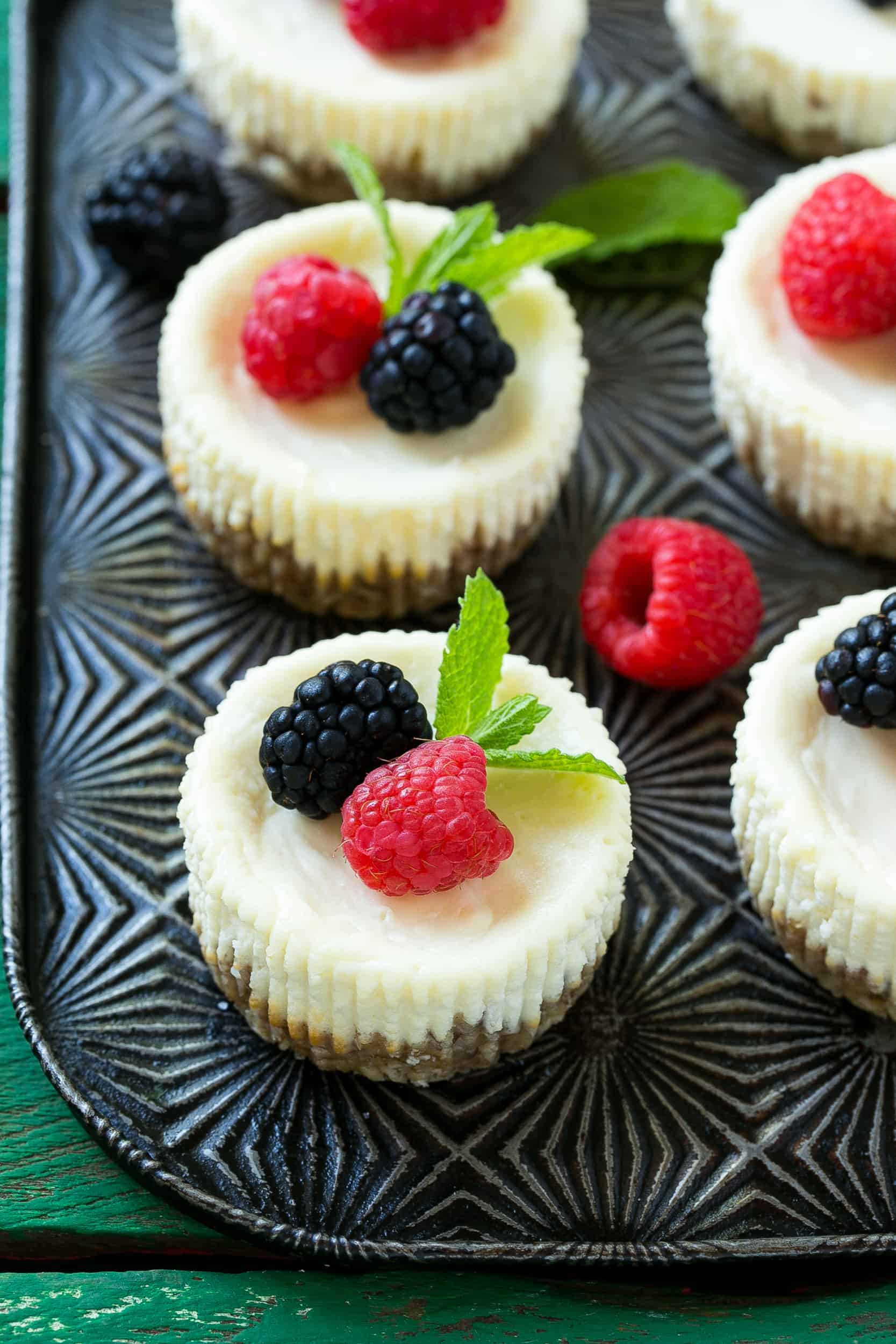  Cheesecake bites on a pan topped with berries and mint twigs