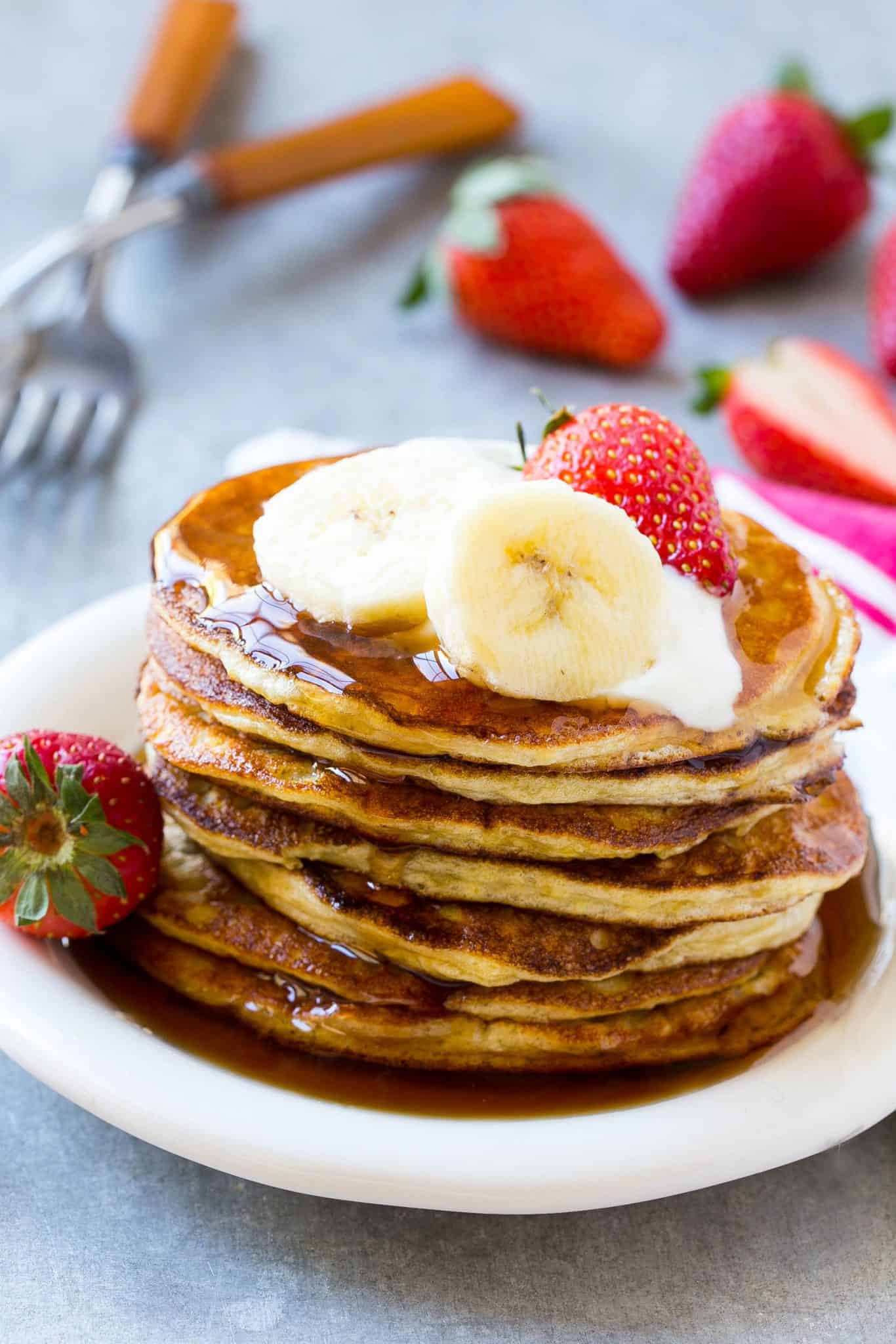 Banana Protein Pancakes on plate with banana slices and strawberries 
