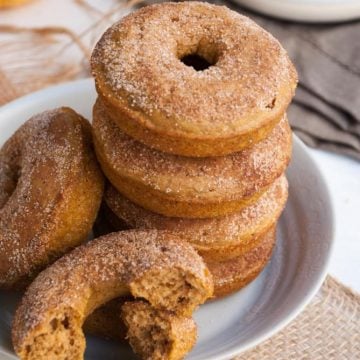 Cinnamon Sugar Pumpkin Donuts stacked together on a white plate