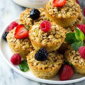 close up side shot of oatmeal muffins on a plate topped with berries