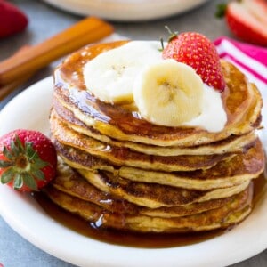 stack of protein pancakes on plate with strawberries and bananas