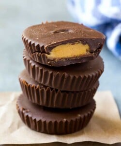 peanut butter cups stacked over each other on a parchment paper.