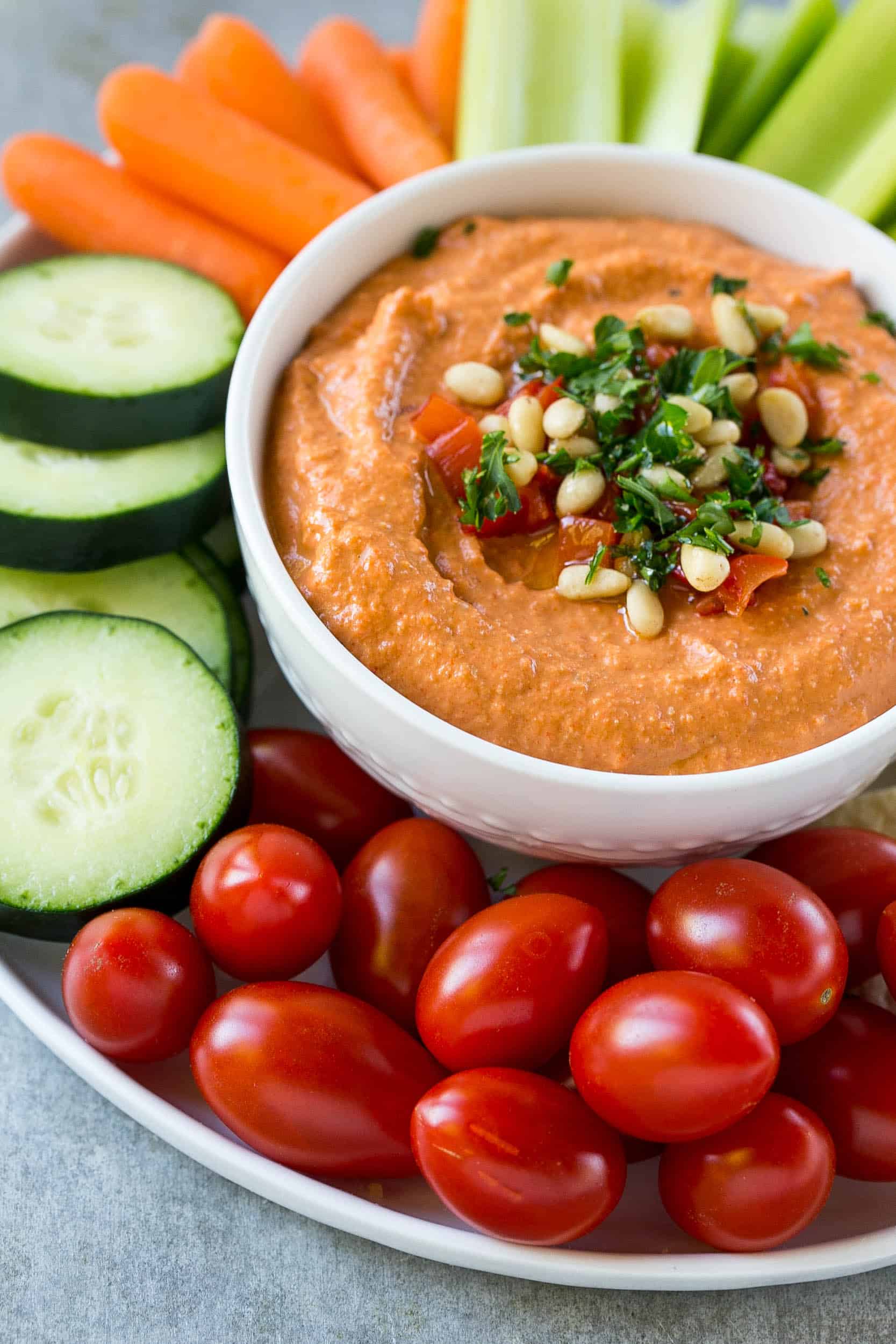 bowl of hummus surrounded by veggies 