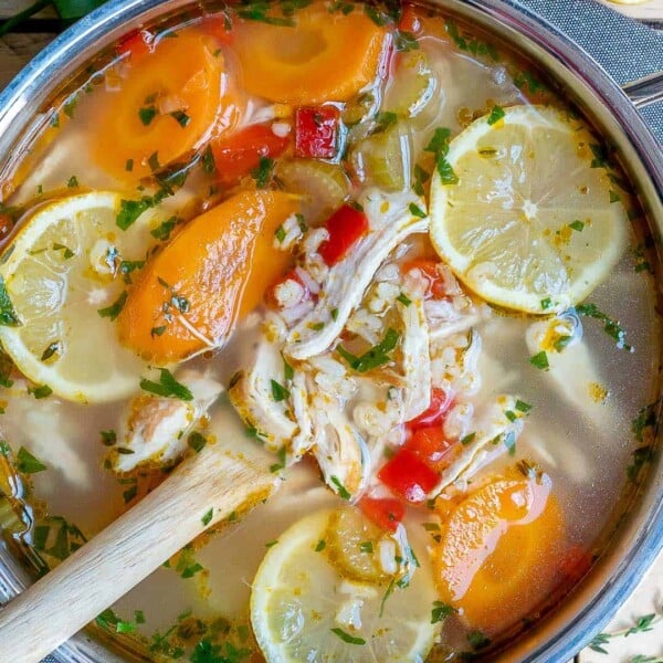 a pot with lemon chicken soup and spoon in pot.