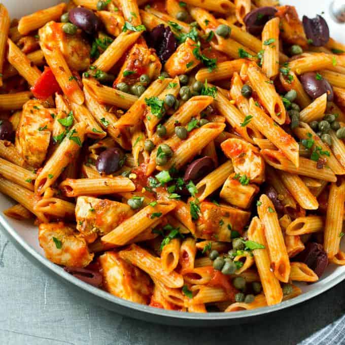 square image of tomato penne pasta with chicken kalamata olives and capers