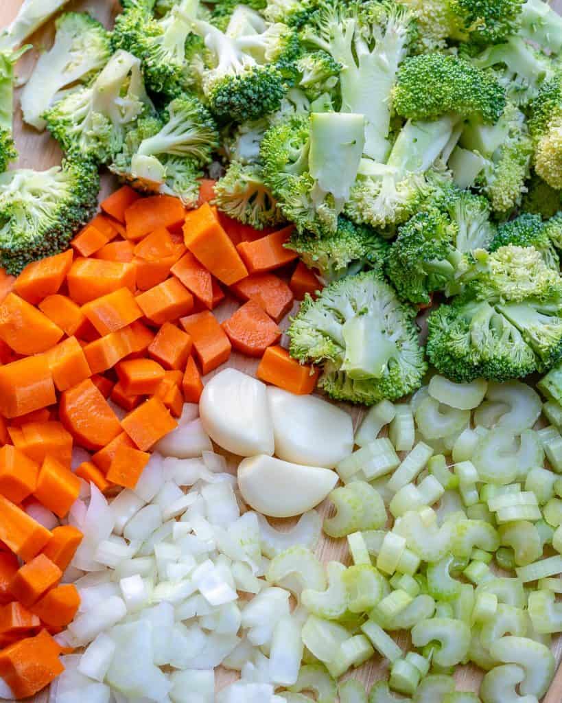 chopped veggies, carrots, broccoli, onion, celery, on a cutting board for Broccoli Cheddar Soup