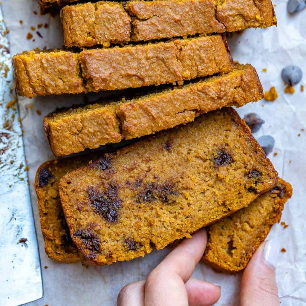 hand holding a piece of Chocolate Chip Pumpkin Bread