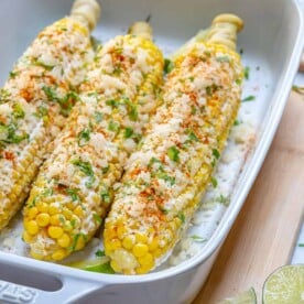 side shot of a dish with 3 corn on the cob street style