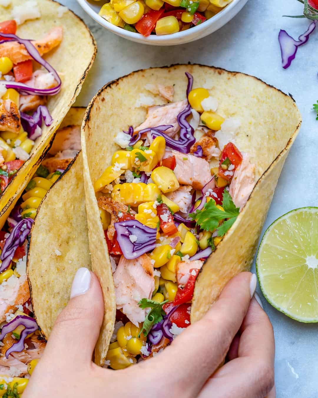 hand reaching out and grabbing one of the fish tacos