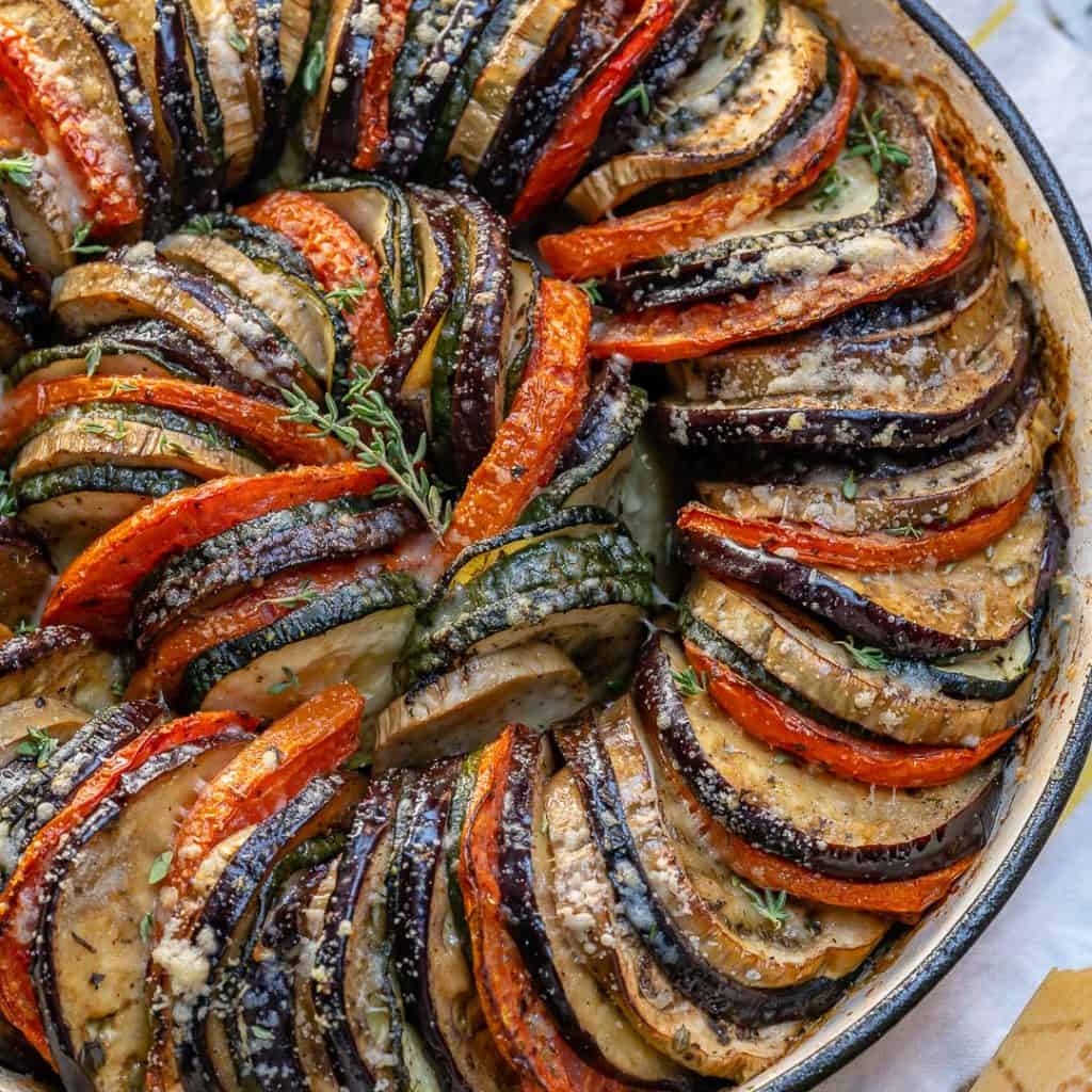 top close up view of slices of zucchini, eggplants and tomatoes stacked next to each other