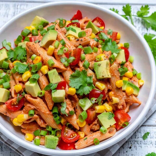 round white plate with taco pasta salad topped with chopped avocado