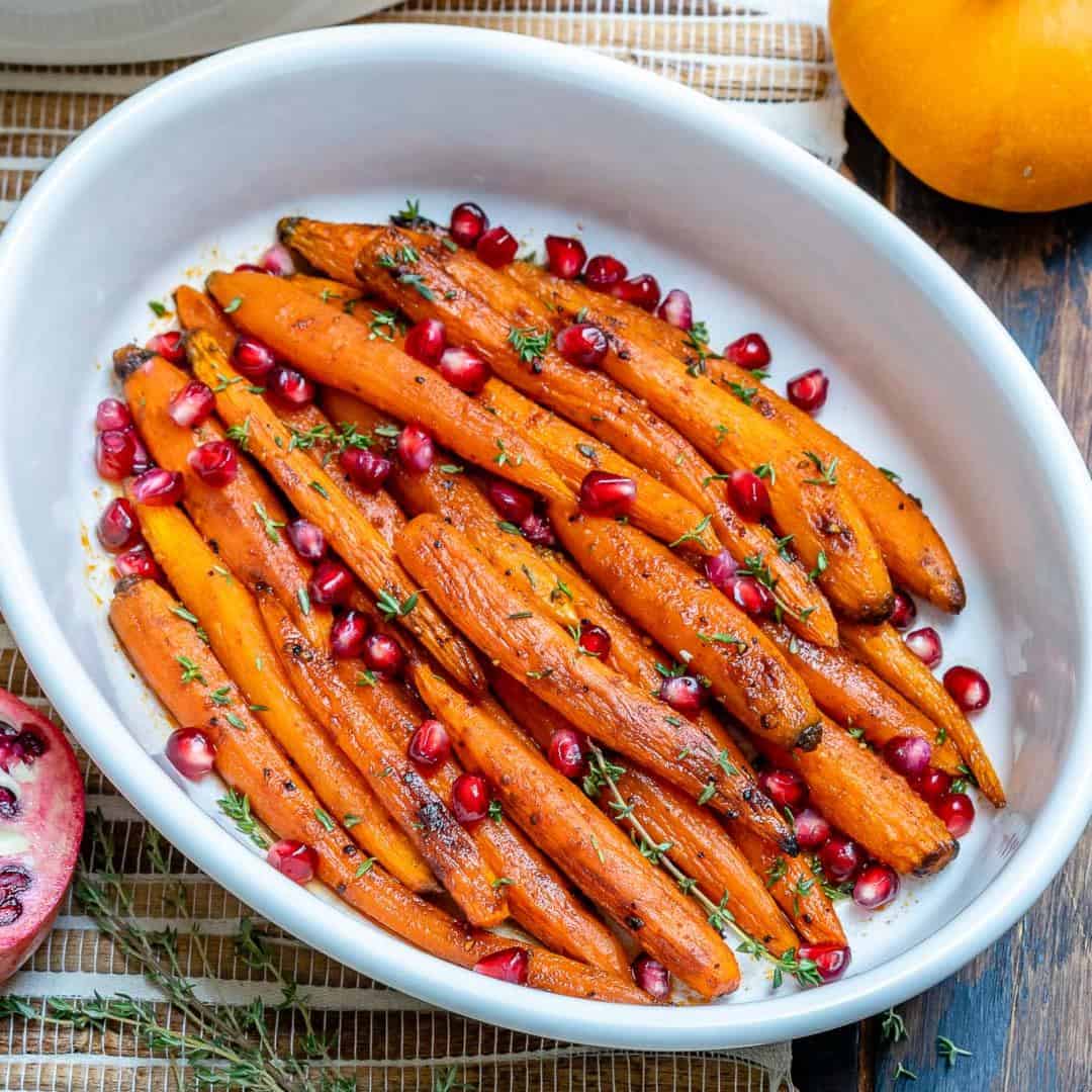side shot of roasted carrots in a white dish
