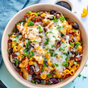 top view of a round bowl of mac and cheese chili recipe topped with melted cheese