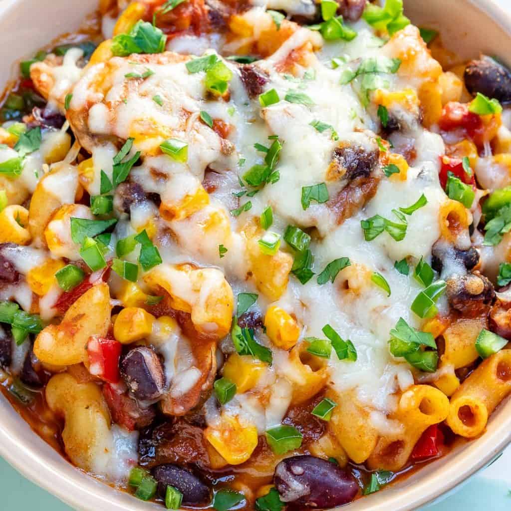 close up view of chili macaroni topped with cheese and green onions
