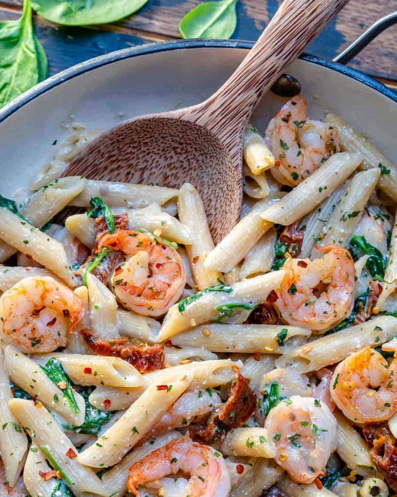 close up of skillet with penne pasta made wiyj sun-dried tomatoes, spinach, shrimp and light cream sauce