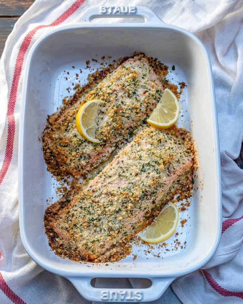 top view of 2 crispy salmon filets that are baked and crispy with lemon slices to garnish