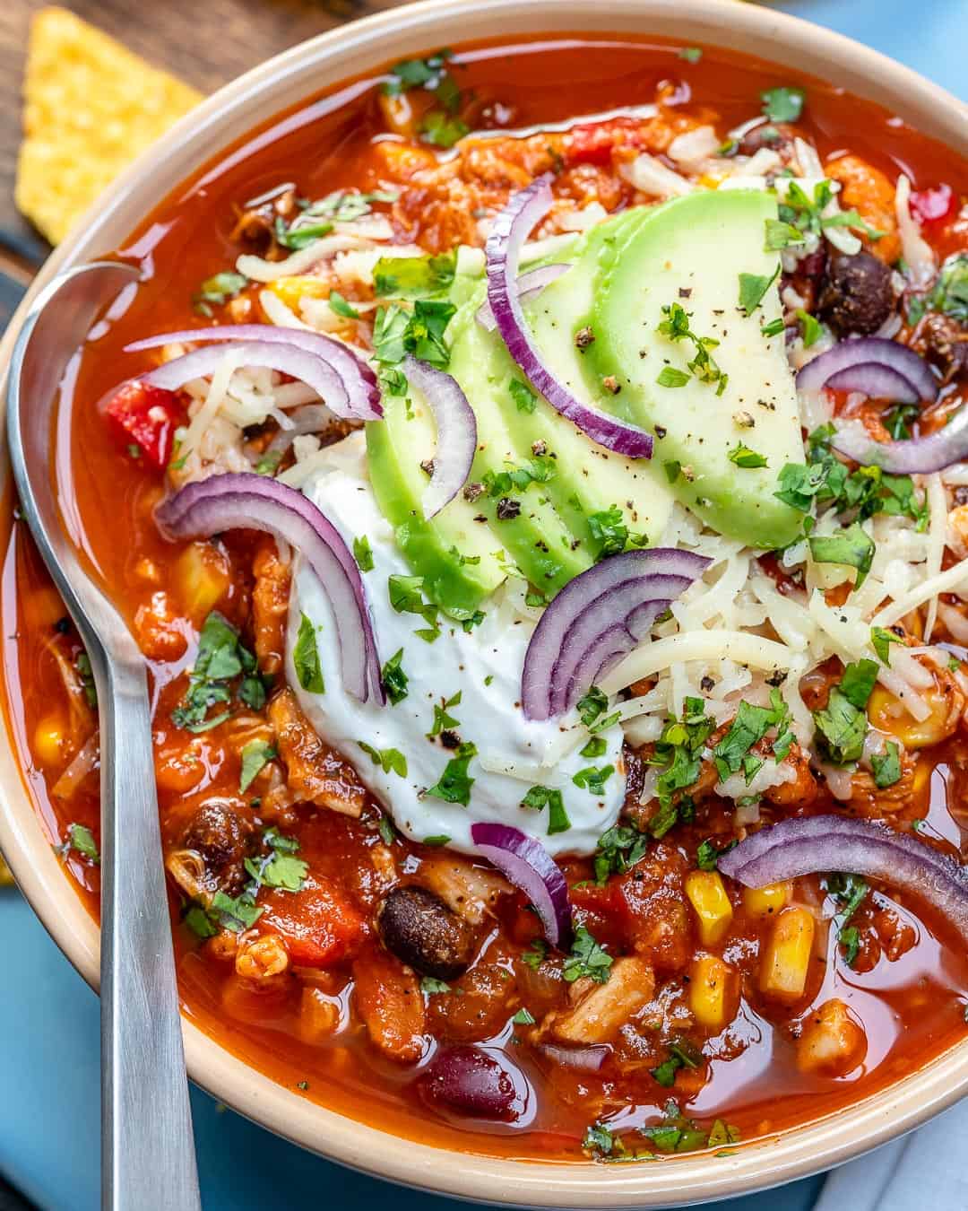 easy chicken chili recipe topped with avocado and sour cream