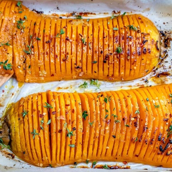 side shot of roasted Hasselback butternut squash on a roasting pan.