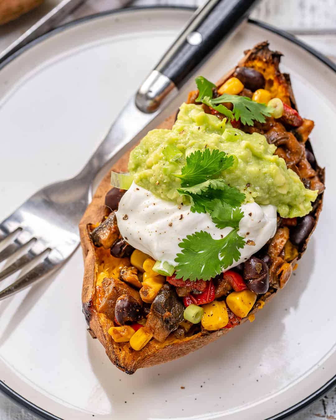 one healthy stuffed sweet potato on plate with fork 