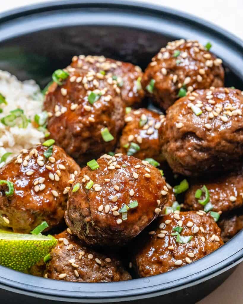 close up of meatballs in a bowl with rice