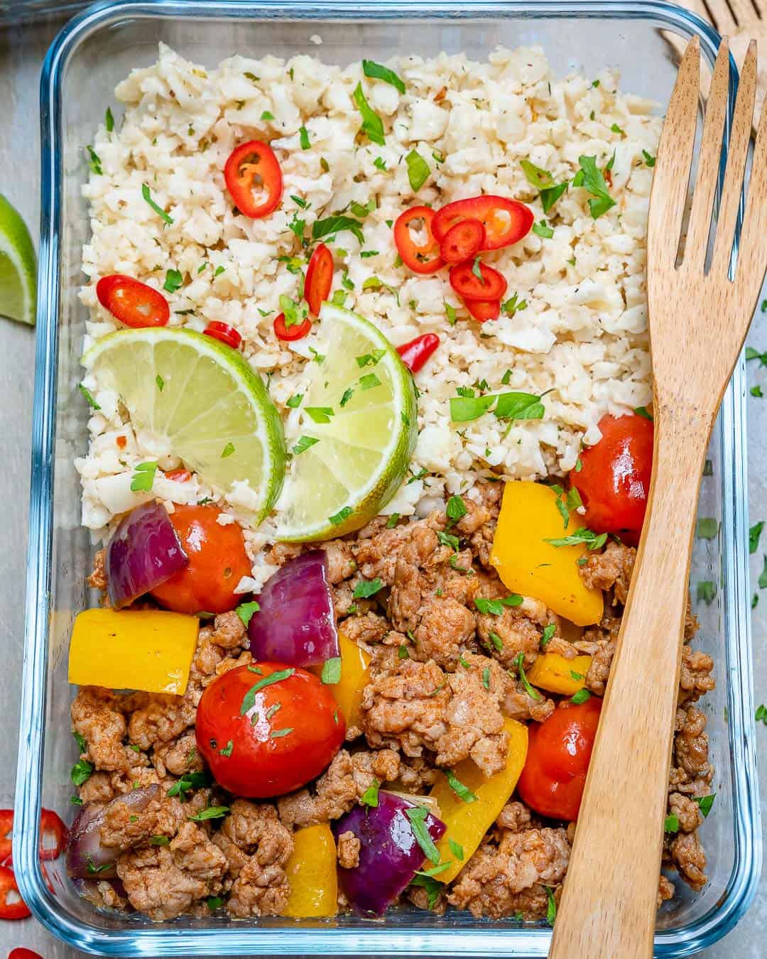 ground turkey recipe in glass container with cauliflower rice, lime, and veggies 