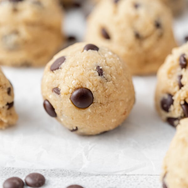side shot of a ball of edible cookie dough bite on a parchment paper