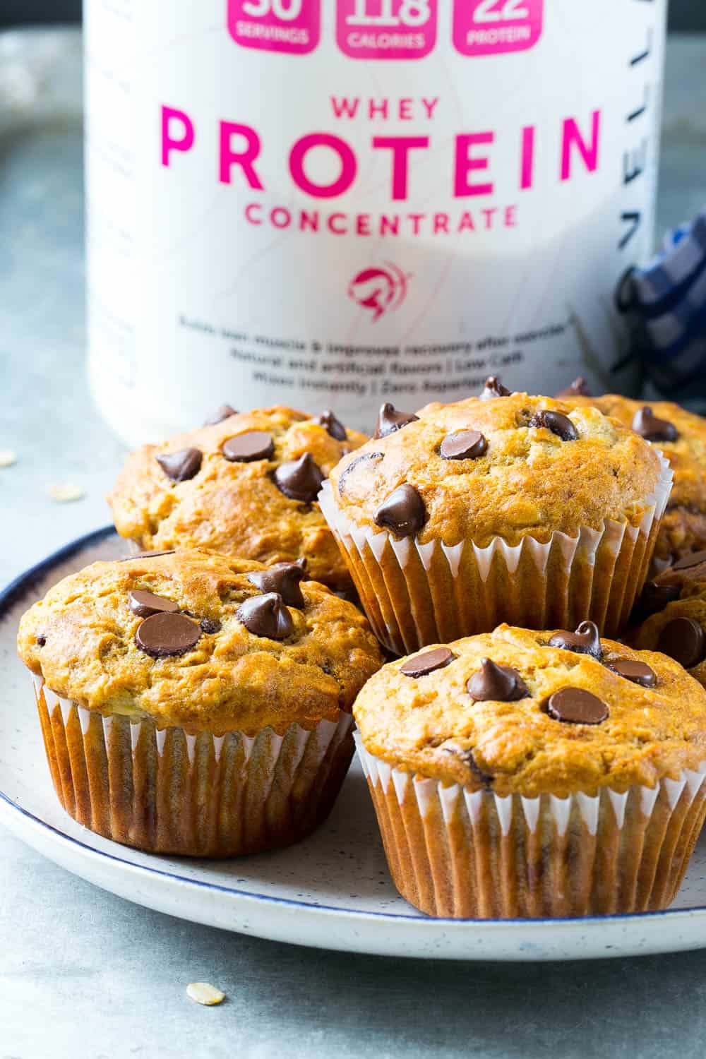 healthy banana muffins on plate with whey powder in background