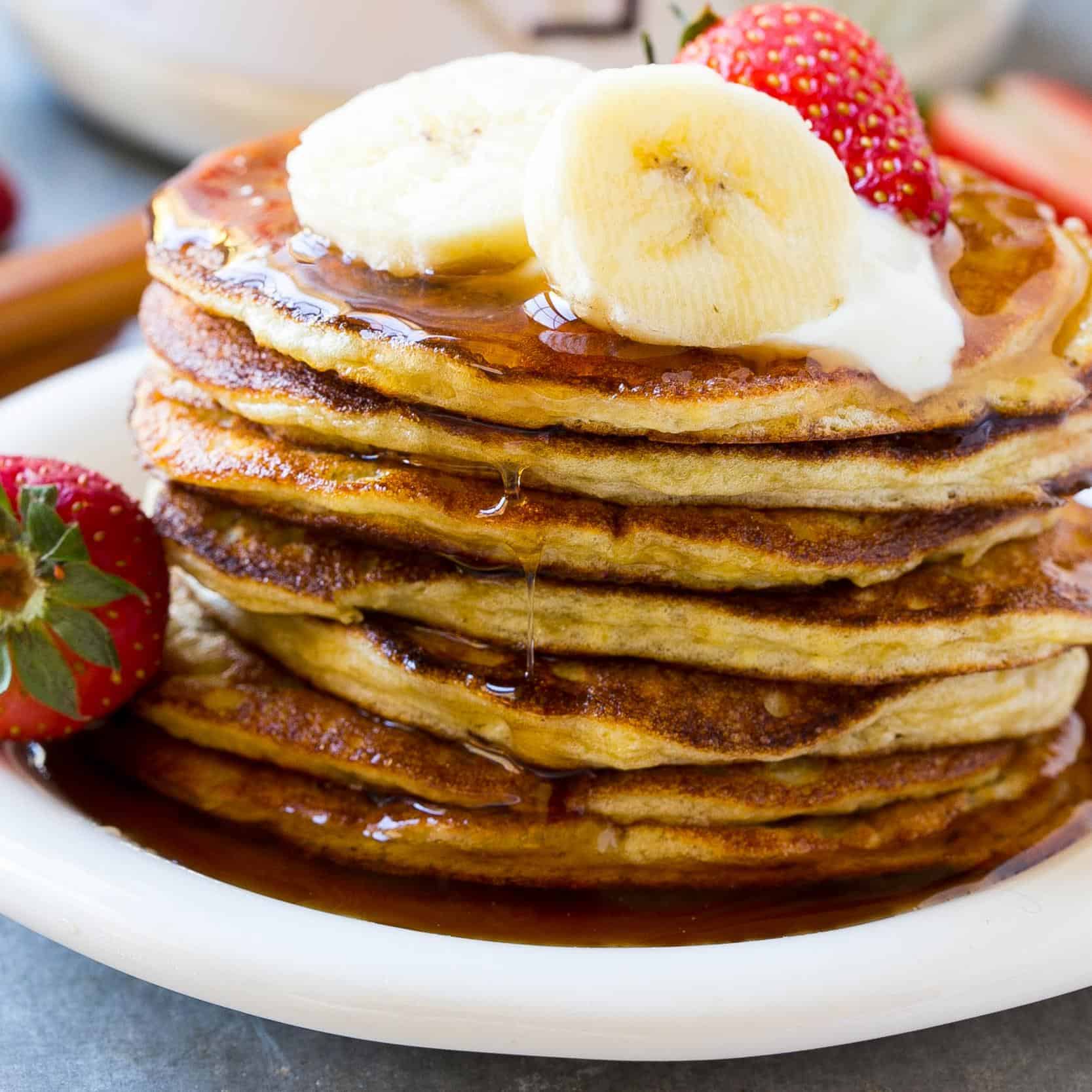  pancakes stacked on plate garnished with syrup