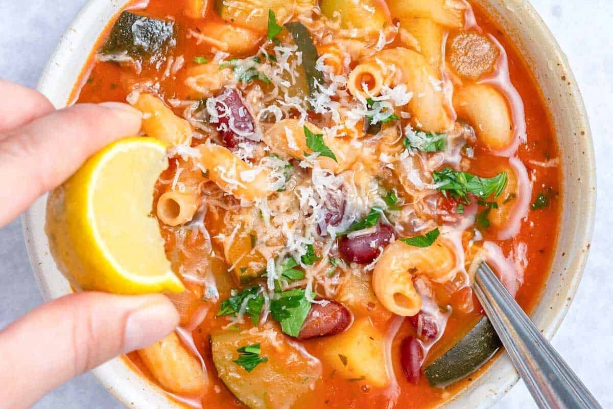 garnishing soup with a lemon wedge.