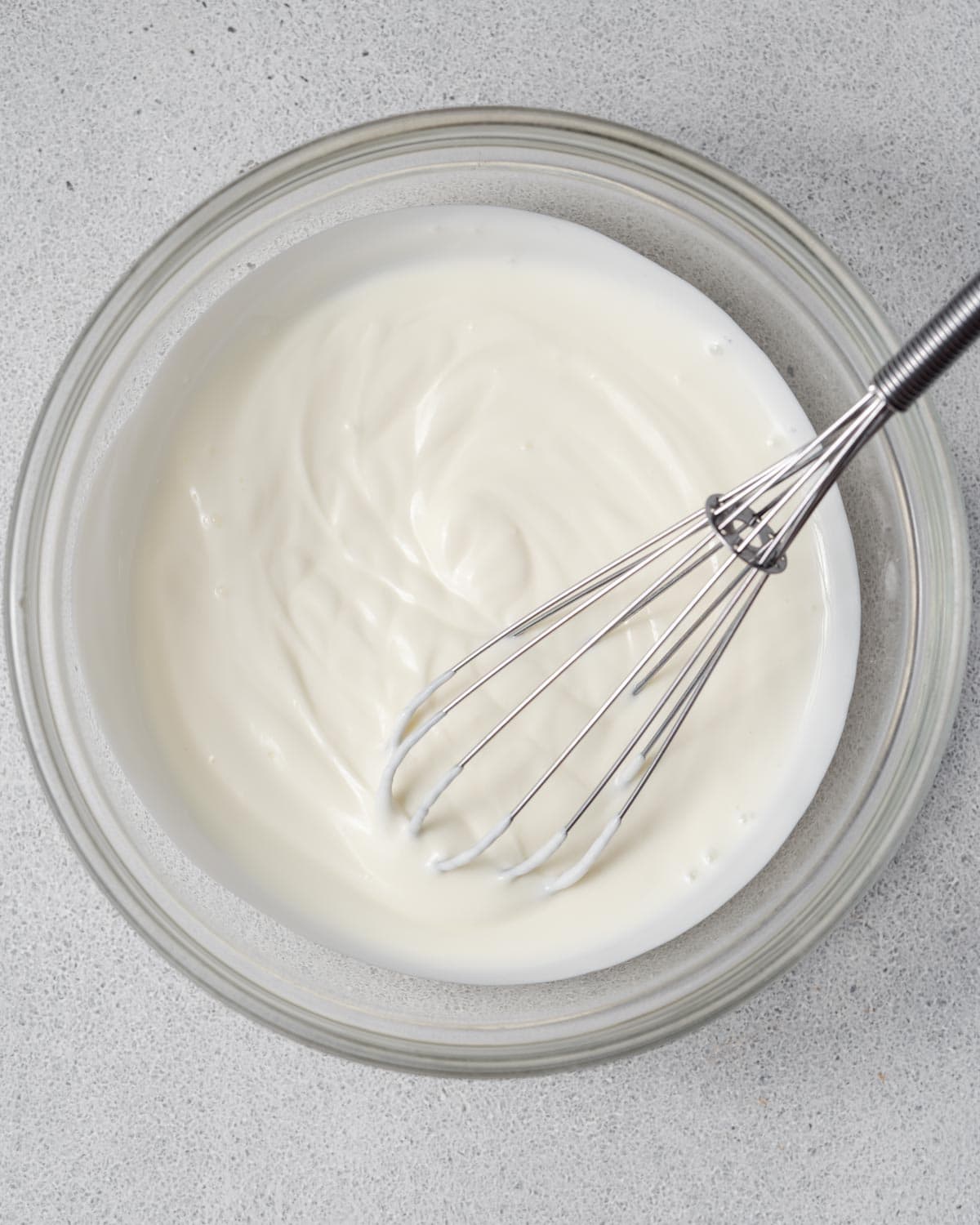 a bowl with cheesecake filling ingredients mixed with a whisk until smooth.