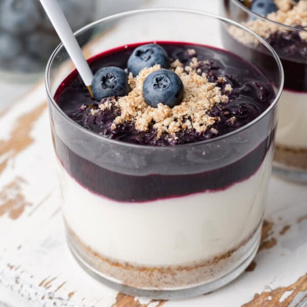 a cup with layered no-bake cheesecake. Bottom layer has the curst, then the cheesecake filling, then topped with blueberry sauce.