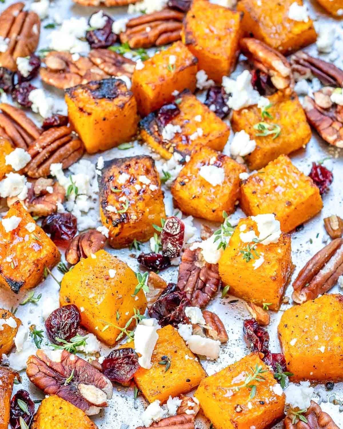 Roasted butternut squash on a sheet pan with pecans and feta cheese.