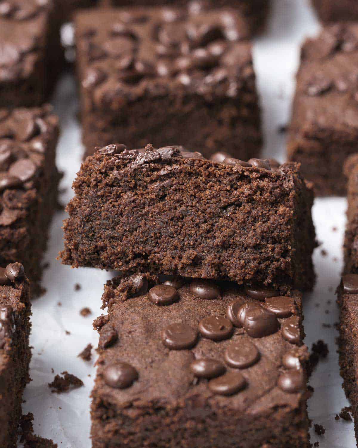 brownie squares on a flat surface with one brownie stacked on another.