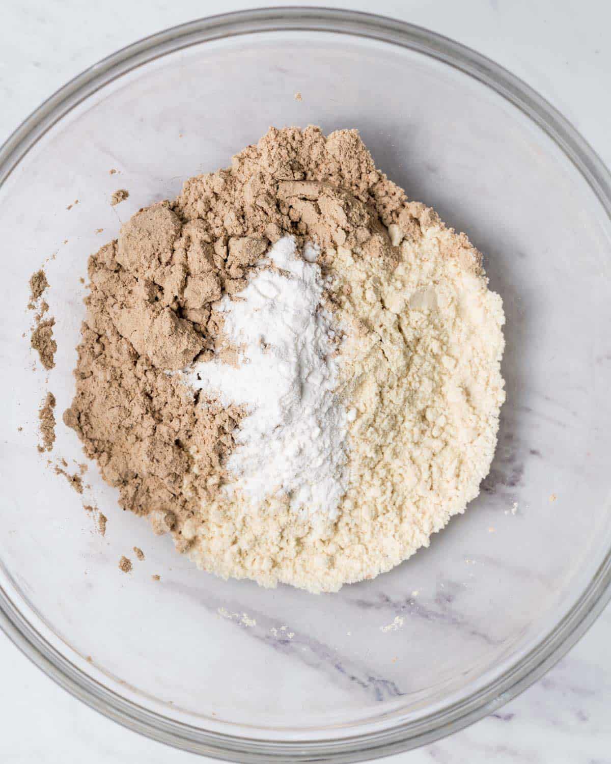 almond flour, protein powder, and baking powder in a clear bowl.