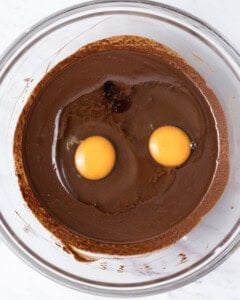 two eggs added over chocolate and sugar mixture.