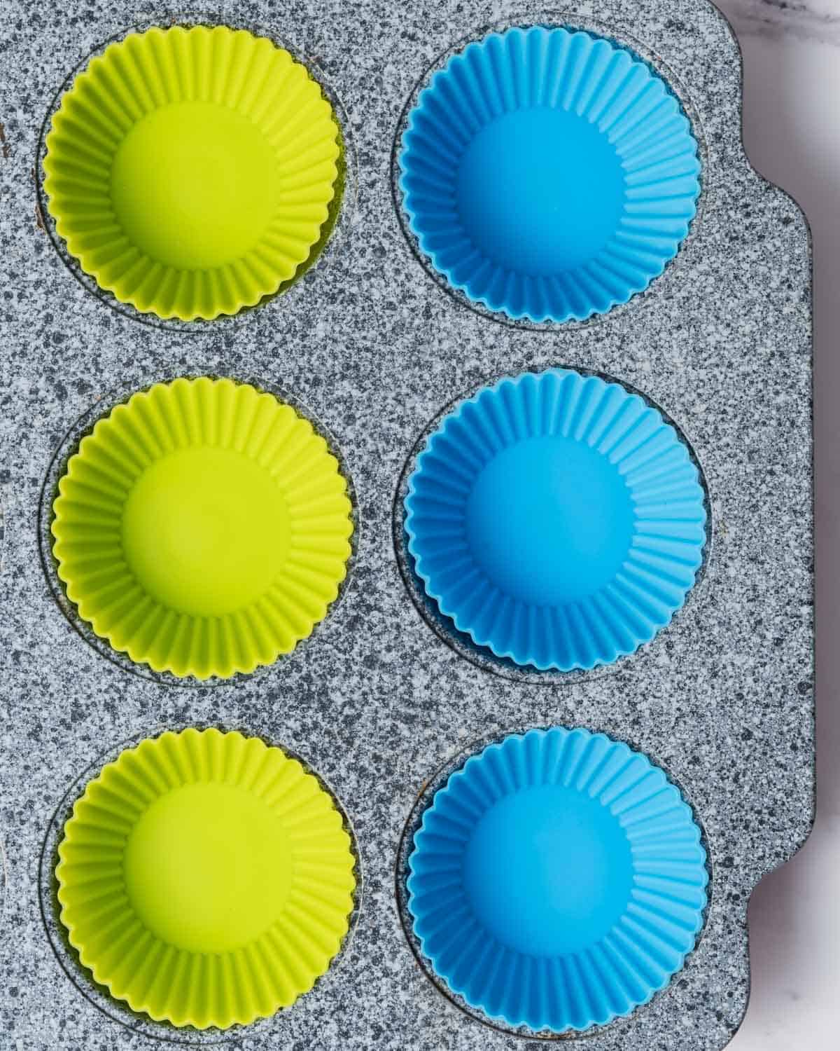 light blue and light green silicone cup liners placed on a pan.