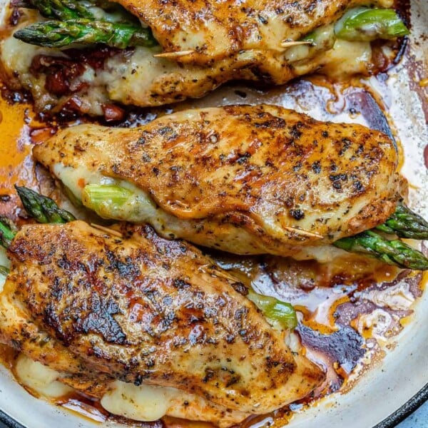 chicken breast stuffed with asparagus and cheese on a pan.