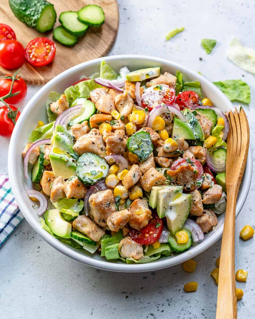 a round bowl of chicken salad with lettuce and a variety of veggies.