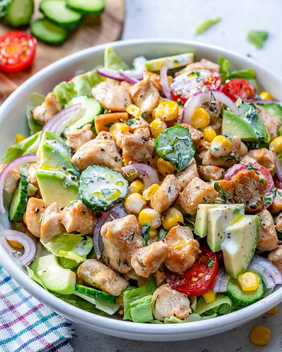 chicken salad in a round dish with a variety of veggies.