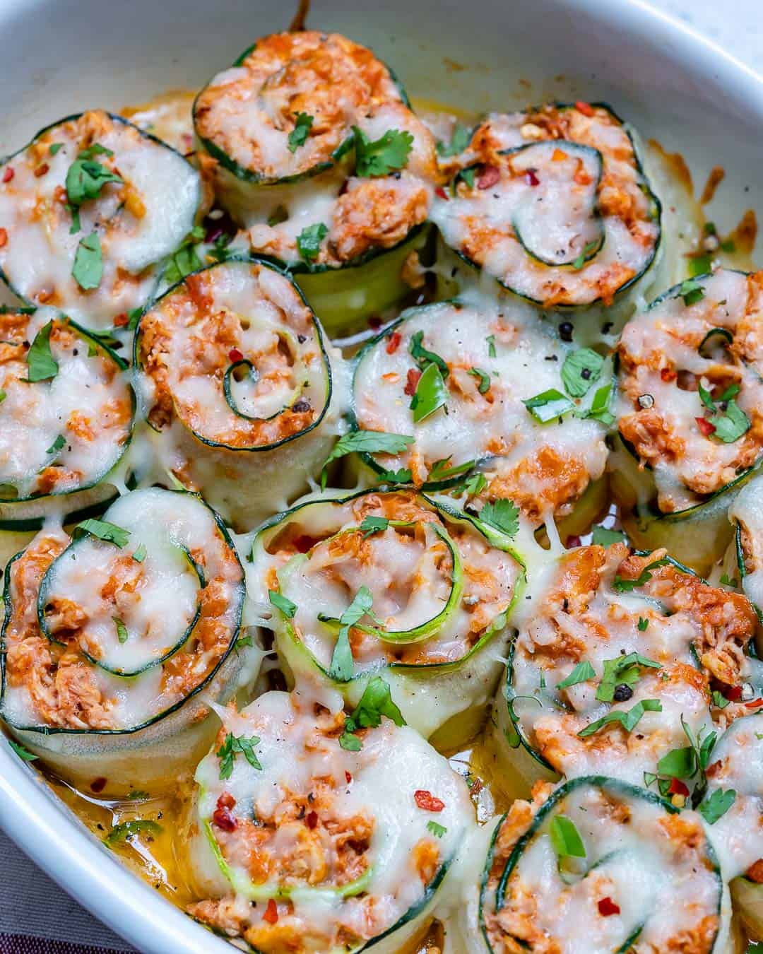 overhead shot of shredded chicken enchilada roll-ups in a dish