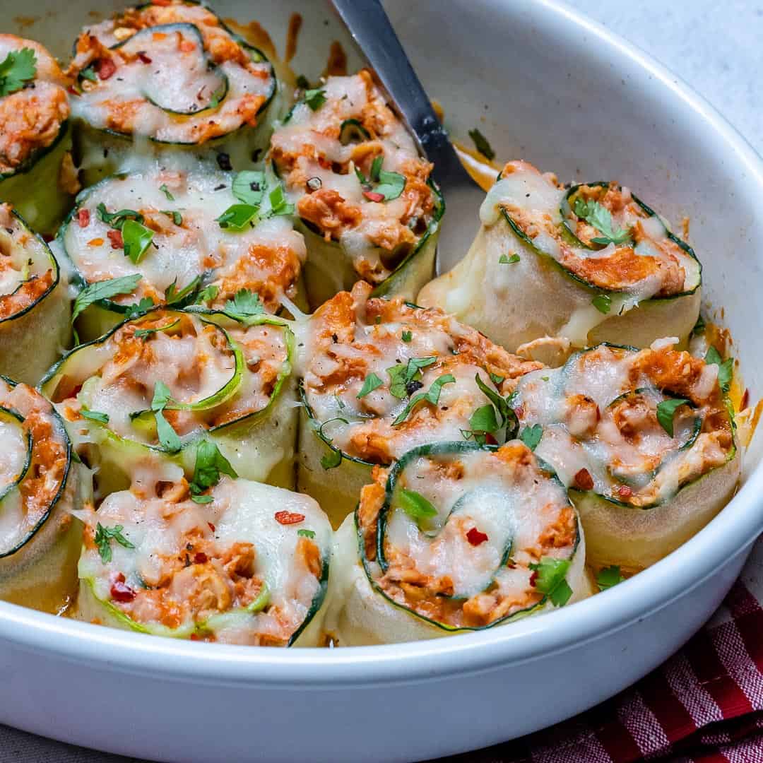 side shot of zucchini enchiladas roll ups in a dish